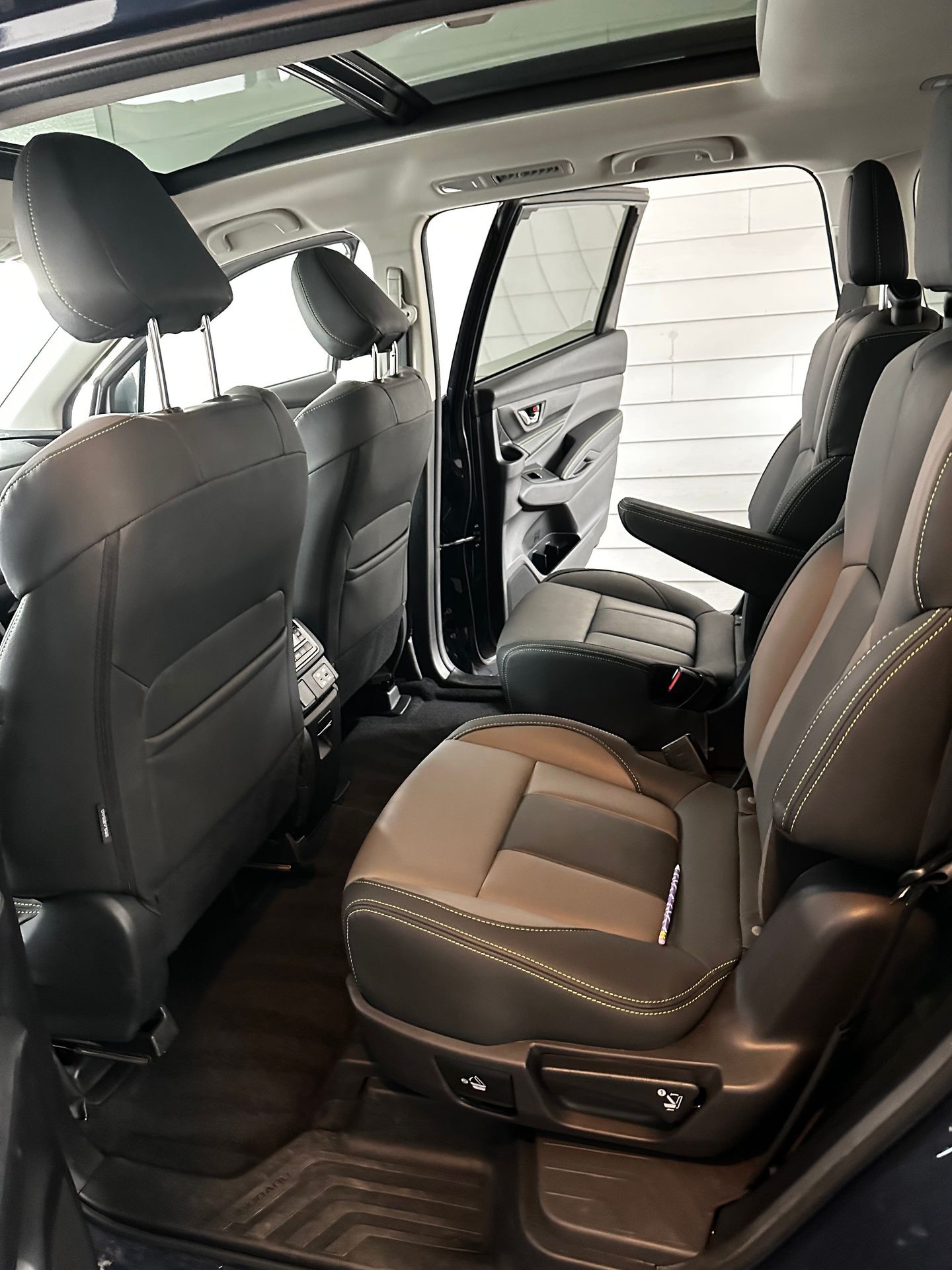 Car detailing and car care concept - Professional using steam vacuum for draining stains